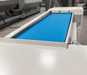 Grinding belt and sanding assembly of a platen surface grinder used for precision material removal, surface finishing, and restoration of flat surfaces on industrial components.