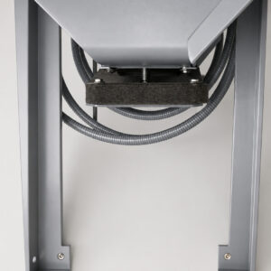 Waste discharge outlet on a bag house dust collector positioned above a 55-gallon drum collection area for capturing dust and debris removed during filtration.