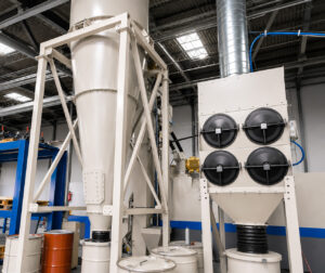 Cyclone separator installed alongside a dust collector and connected to a shot blasting system, providing efficient pre-separation of abrasive fines and dust before final filtration.
