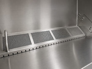 Filter and drain assembly located at the bottom of an LS Industries Drum Lid Washer, designed to capture debris and direct wastewater flow for efficient system operation.