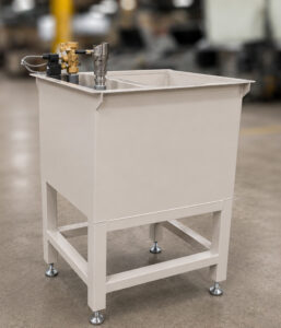 Solution tank of an LS Industries Drum Lid Washer, designed to store and recirculate wash water and cleaning solution throughout the cleaning process.