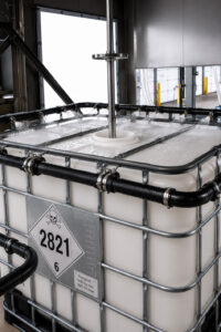 External washing spray bar on an LS Industries IBC Tote Washer moving around an IBC tote, delivering high-pressure water to thoroughly clean all exterior surfaces.